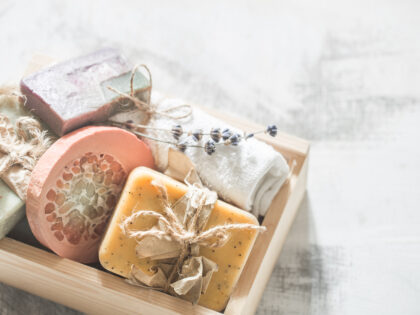 Natural soap Spa set in wooden box place for text on white background, concept of body care and healing